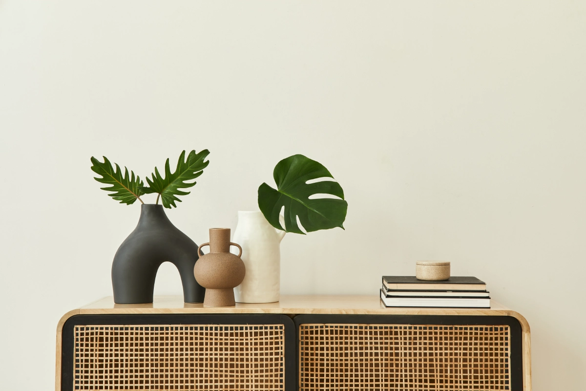 Vases, plants, and books on a cabinet.